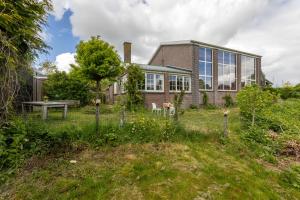 a house with a garden in front of it at Appartement de Tuinkamer in Kampen