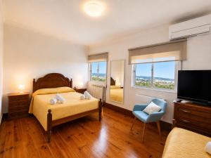 a bedroom with a bed and a chair and a television at Casa Machado in Vila Real