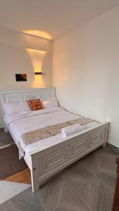 a bedroom with a large white bed in a room at Stlounge-kisaju in Stony Athi