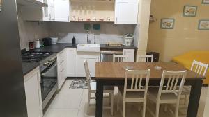 a kitchen with a table and chairs and a stove at Tan-Nahal Court Apartment, Sannat Gozo in Sannat