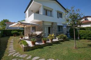 a house with an umbrella and some potted plants at B&B Ortensia in Forte dei Marmi