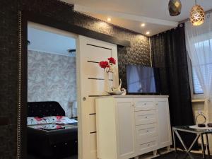 a bedroom with a mirror and a bed and a dresser at Apartament Glamour in Rybnik