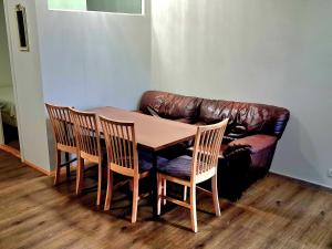 a table and chairs and a leather couch in a room at KEF QuickStay Apartments in Keflavík