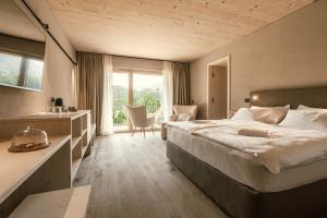 a hotel room with a large bed and a bathroom at Hotel Tulie in Most na Soči
