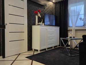 a living room with a tv on a dresser at Apartament Glamour in Rybnik