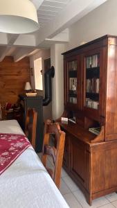 a bedroom with a large wooden cabinet and a desk at Le cordonnier du Staedel in La Petite-Pierre