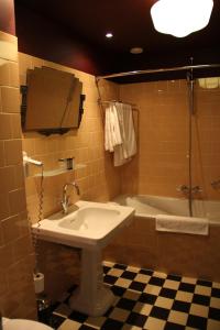 een badkamer met een wastafel en een bad bij Augusta Hotel in IJmuiden