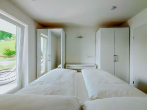 two white beds in a room with a window at Apartment Pegasus by Salzkammergood Living in Tauplitz