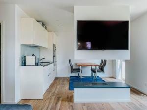a living room with a table and a tv on a wall at Apartment Pegasus by Salzkammergood Living in Tauplitz