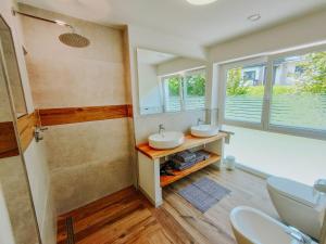 a bathroom with two sinks and a shower at Apartment Pegasus by Salzkammergood Living in Tauplitz +19 photos