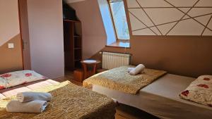 a small room with two beds and a window at Pokoje Szmaragd in Kudowa-Zdrój