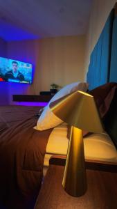 a bedroom with a bed with a lamp and a tv at La Suite de Antonio Shared Property PRIVATE stay NYC 18mins in North Bergen