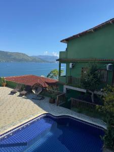 a house with a swimming pool next to a building at Pousada Platôdasilhas in Angra dos Reis +20 photos