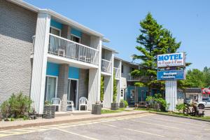 a hotel sign in front of a building at Motel de l'Anse a l'Eau in Tadoussac