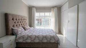 a bedroom with a large bed with a large window at The Kempton Star in Kempton Park