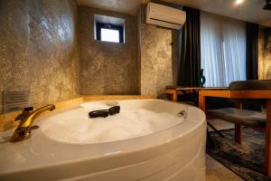 a bath tub with a sink in a room at Cappadocia Divin House in Göreme +213 photos