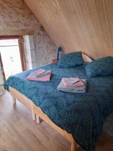 a bedroom with a bed with green sheets and pillows at Au Coeur de la Cour in Saint-Georges-sur-Cher