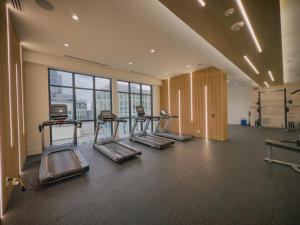 a gym with several treadmills in a room with windows at Central City Suites with Free Parking in Toronto