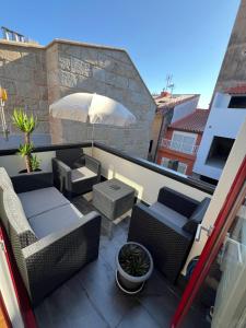 a patio with chairs and an umbrella on a balcony at Mar De Pedra in Cangas de Morrazo