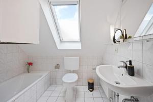 a bathroom with a sink toilet and a skylight at Zaunkönigin in Norden +63 photos
