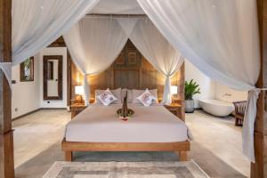 a bedroom with a bed and a bath tub in a room at Casa Sepang in Munggu +44 photos