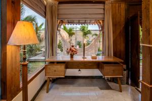 an office with a desk and a large window at Casa Sepang in Munggu