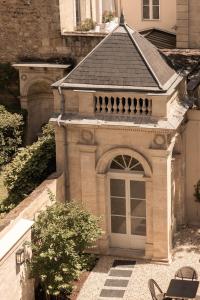 a small building with a door in a yard at Hotel des Quinconces Bordeaux Centre in Bordeaux