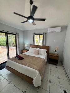 a bedroom with a bed with a ceiling fan at Private 2 Bedroom Home with Pool Near El Coco Beach in Coco +26 photos