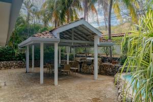 a pavilion with a table and chairs under it at Private 2 Bedroom Home with Pool Near El Coco Beach in Coco