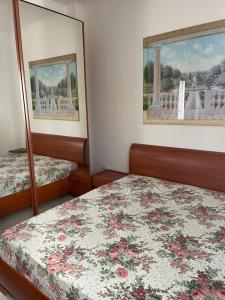 a bedroom with two beds and a mirror at Happy Oasi in Lido Adriano