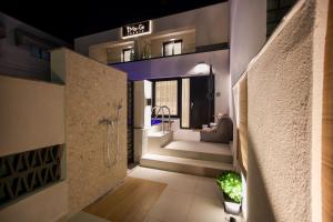 a bathroom with a walk in shower next to a staircase at iMa-Ge Luxury in Nea Vrasna
