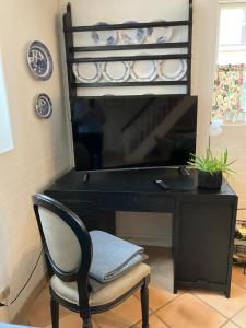 a black desk with a chair in front of a piano at Madam Bundsens Huse in Assens