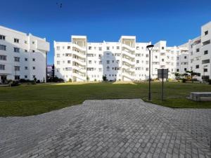 a large white building with a park in front of it at MO Buxton Lux Apartment- Mombasa CBD 70 in Frere Town