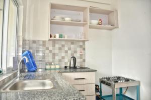 a kitchen with a sink and a stove at MO Buxton Lux Apartment- Mombasa CBD 70 in Frere Town