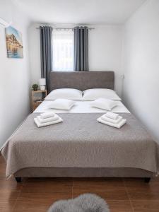 a bedroom with a large bed with two towels on it at Room Jakov in Šibenik