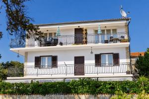 a white building with balconies and a bird on top at Apartmani Bonaca in Pakoštane