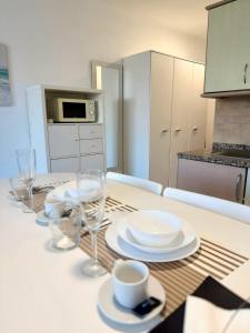 a kitchen with a table with plates and wine glasses at Edificio Las Marañuelas, Puerto La Cruz, Islas Canarias Tenerife in Puerto de la Cruz +52 photos