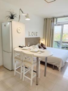 a room with a white table and a bed at Edificio Las Marañuelas, Puerto La Cruz, Islas Canarias Tenerife in Puerto de la Cruz