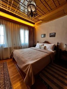a bedroom with a large bed and a chandelier at MetsoVillas στο κέντρο του Μετσόβου in Metsovo