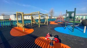 a childrens playground with an orange playground equipment at Seawick Holiday Park in Jaywick Sands