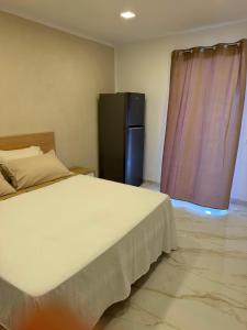 a bedroom with a large bed and a refrigerator at Mare D'amare in Diamante