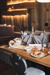 a wooden table with plates of food on it at Kessler's Mountain Lodge in Natz-Schabs