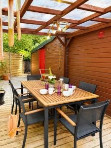 a wooden table and chairs on a patio at Chalet Forestôchat in Tressé