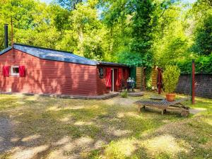 a red barn with a picnic table in a yard at Chalet Forestôchat in Tressé