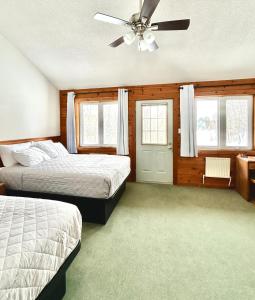 a bedroom with two beds and a ceiling fan at Quiet Bay Lakeside Escape in Magnetawan +65 photos