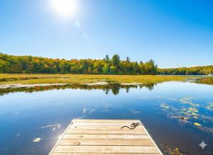 a dock in the middle of a lake at Quiet Bay Lakeside Escape in Magnetawan