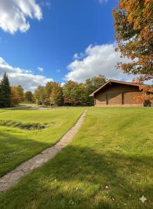 a grassy field with a building in the distance at Quiet Bay Lakeside Escape in Magnetawan