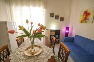a dining room table with a vase of flowers on it at White Duomo Rooms in SantʼAgata di Militello