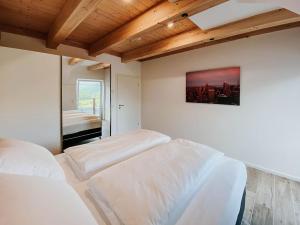 a bedroom with two white beds and a window at Penthaus Aldebaran by Salzkammergood Living in Tauplitz