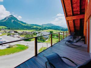 a balcony with a chair and a view of a town at Penthaus Aldebaran by Salzkammergood Living in Tauplitz